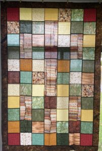 Quilt with squares of browns and greens