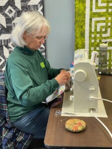 Volunteer making quilts at a sewing machine