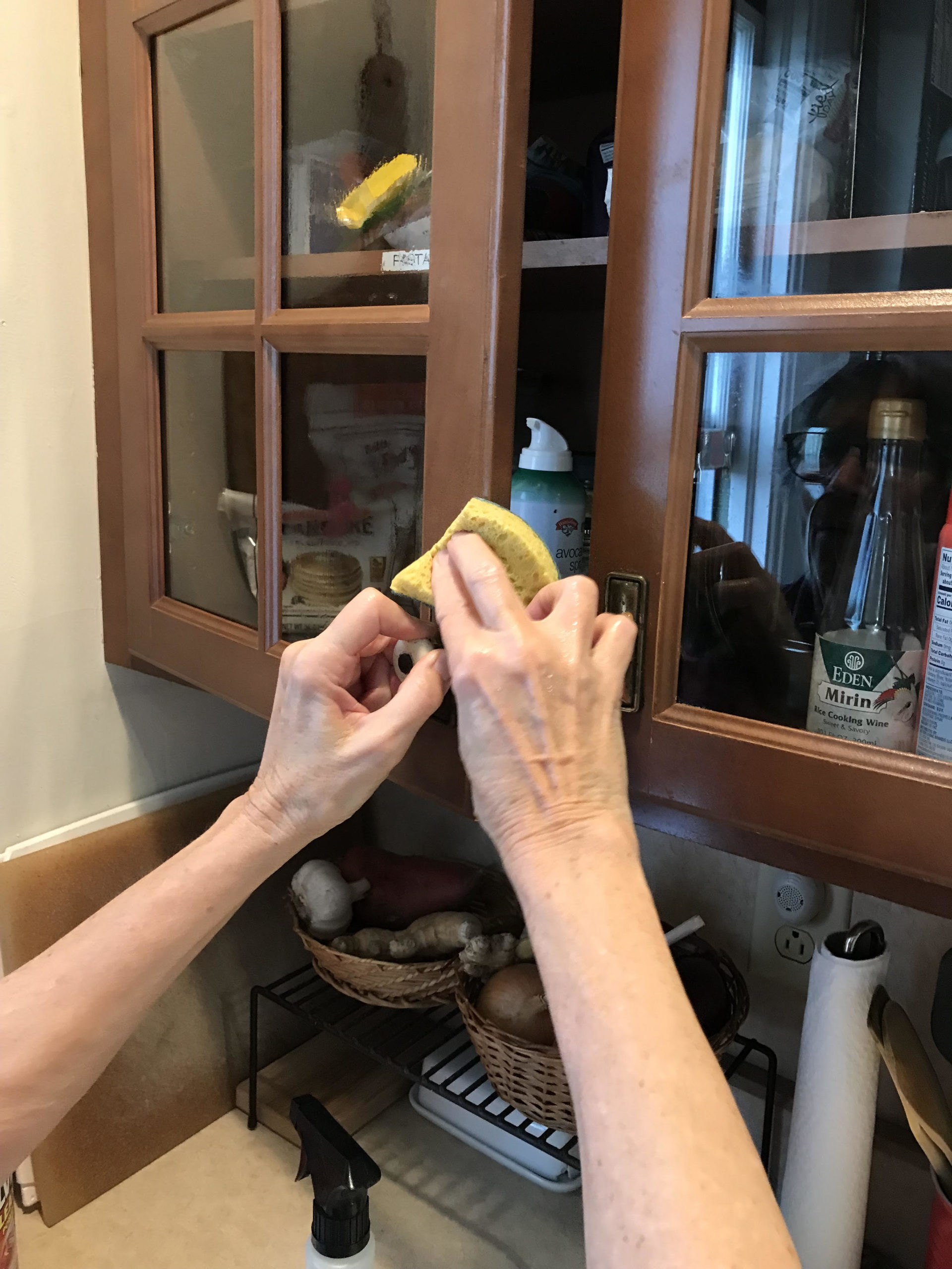 Hands cleaning a cabinet